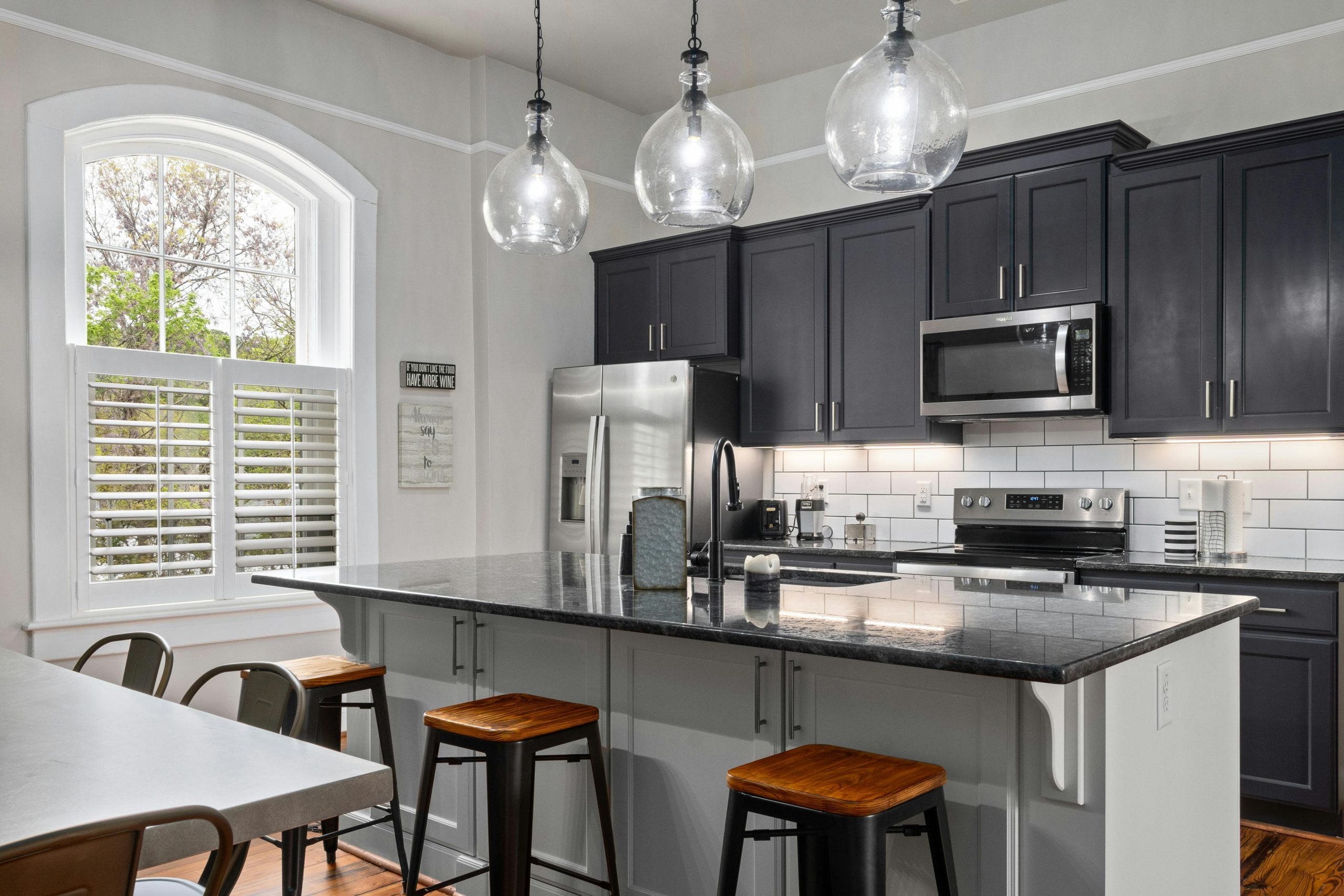pexels-curtis-adams-1694007-24245747 shaker kitchen in two tone grey and a breakfast bar with dark coloured stools