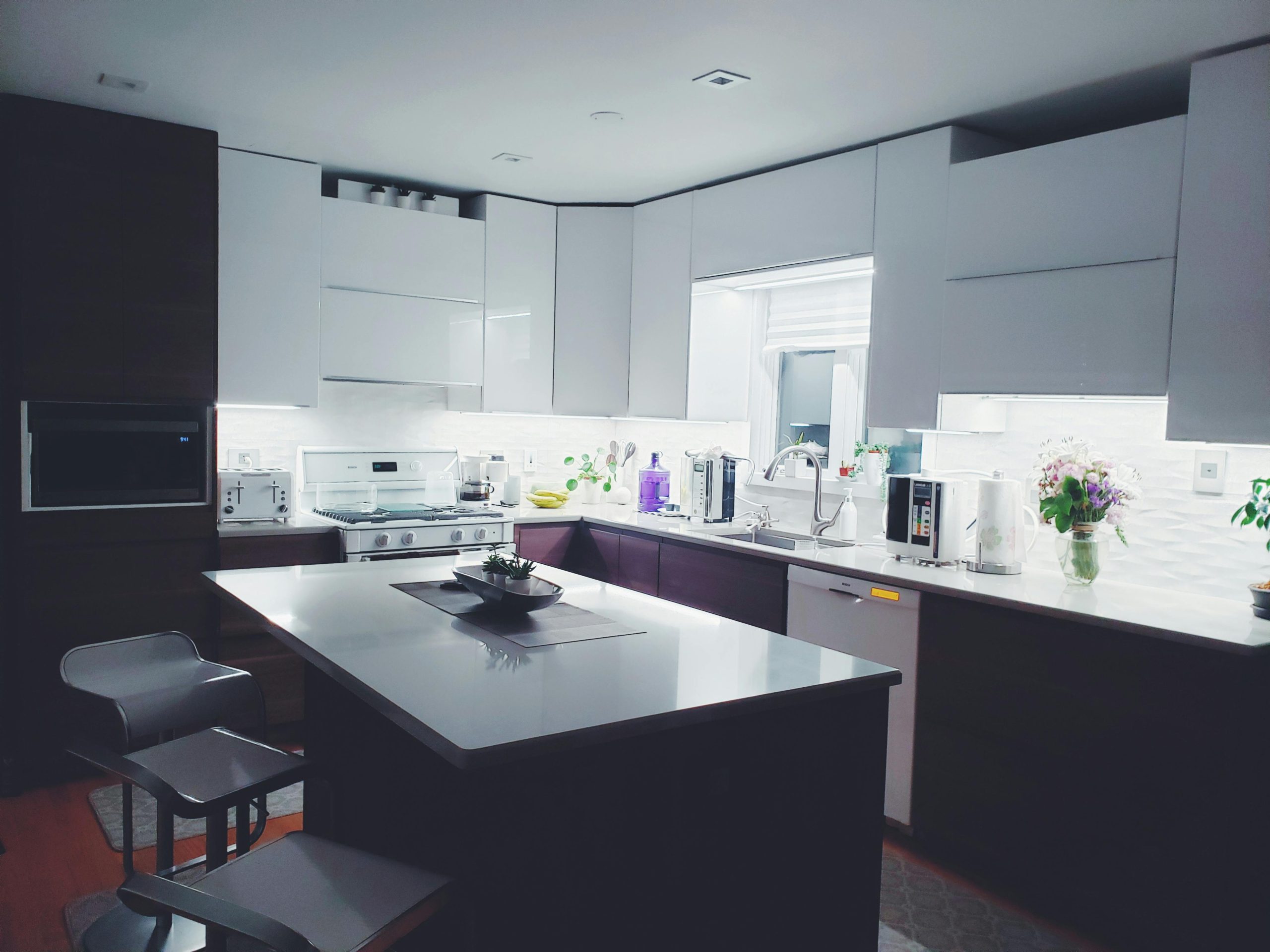 a organised kitchen with a large island and chairs